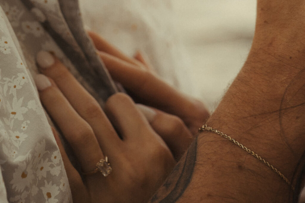 Woman rests her hands on her fiance's chest.