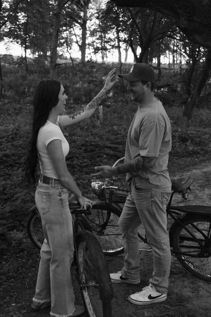 Woman fixes her fiance's ball cap as they go on a date with bikes.