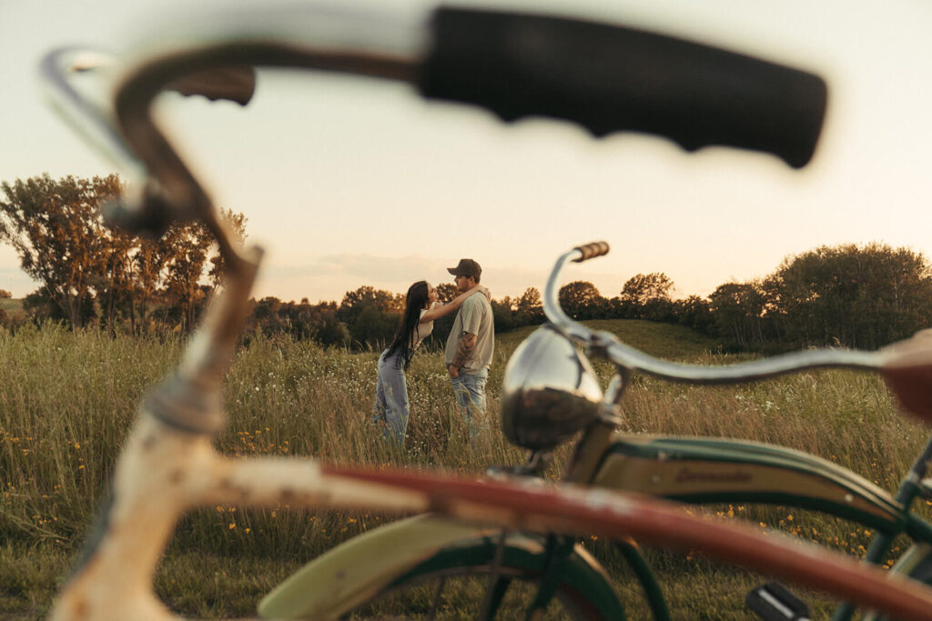 Engaged couple plays in the meadow grass in White Bear Lake, Minnesota.