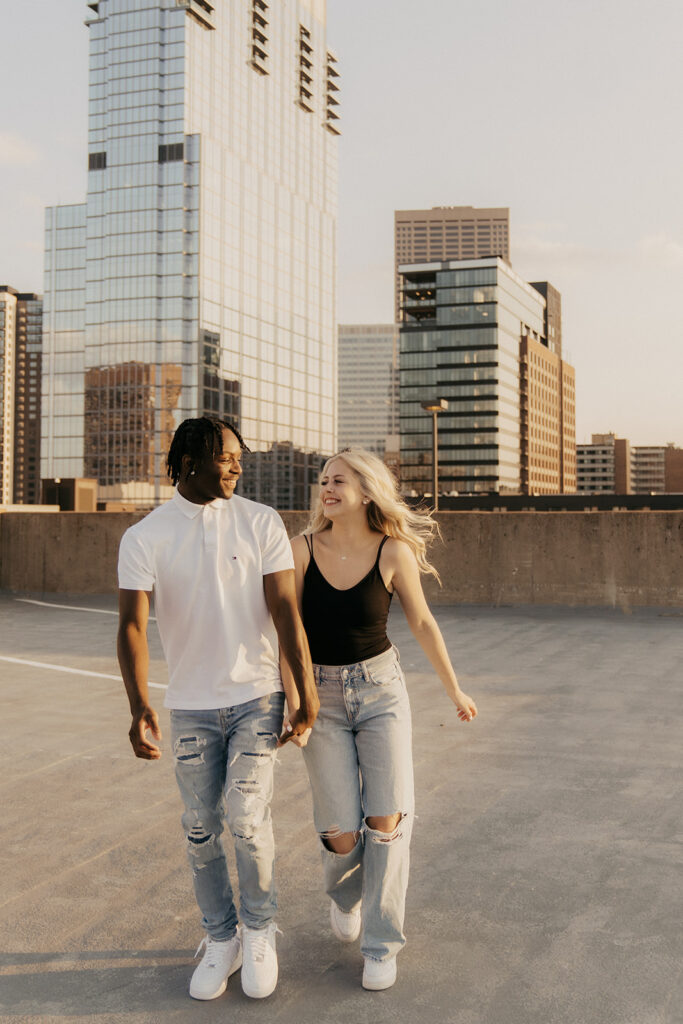 Girl and her boyfriend walk on parking ramp hand in hand during senior photos Minneapolis