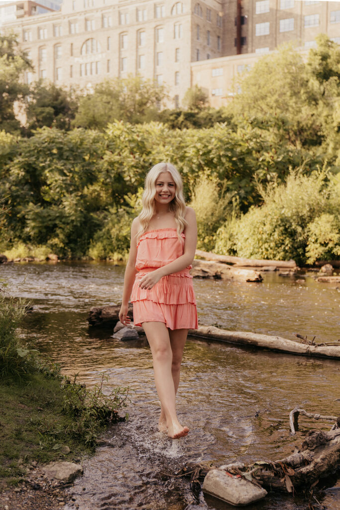 Girl holds her sandals in her hand while kicking water
