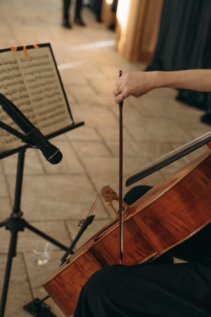 A cellist performs live ceremony music at Equestria West, setting a classical tone for a romantic fall wedding.