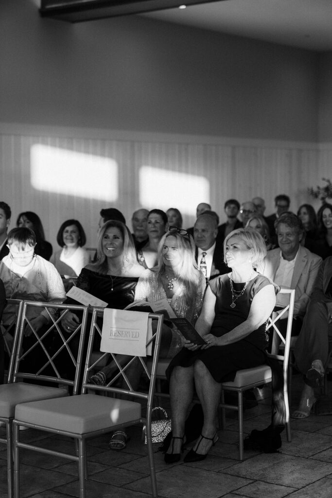 Guests take their seats for a candlelit November wedding ceremony at Equestria West, sunlight spilling onto the front row.