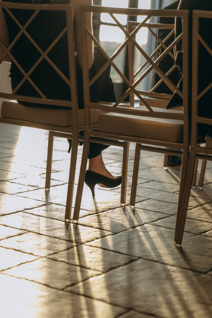Guest’s high heels catching golden light through ceremony chairs — a quiet moment from a fall wedding in Chaska.