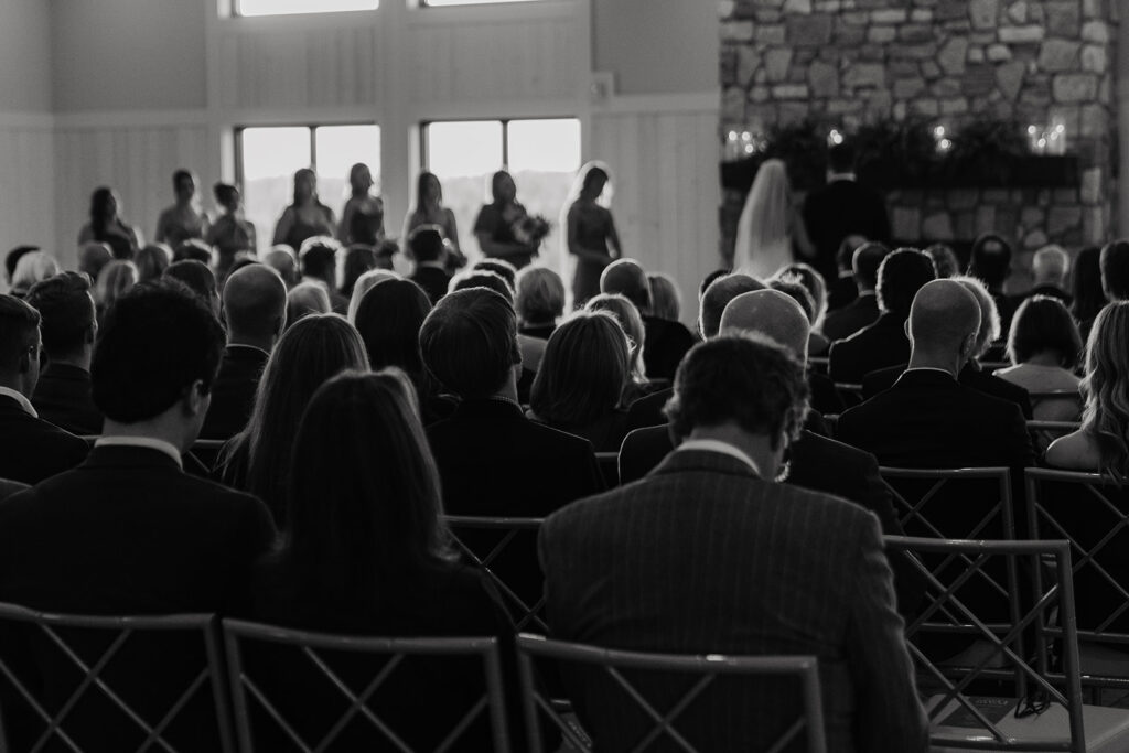 Black and white photo of guests watching a candlelit November ceremony unfold at Equestria West in Chaska, Minnesota.