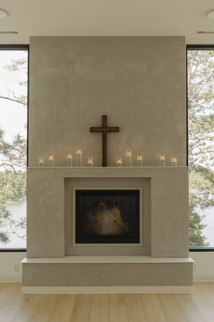 Modern chapel with handcrafted wooden cross and candles on the mantle