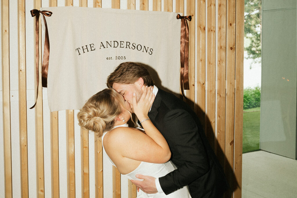 Groom dips bride in a kiss to chorus of cheers from wedding guests