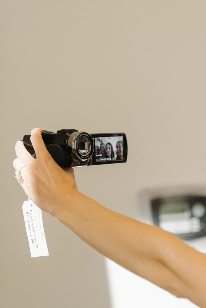 Wedding guests film a message for the bride and groom on camcorder