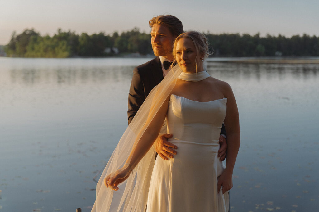 Bride and groom look off into the distance during blue hour timeless wedding photos
