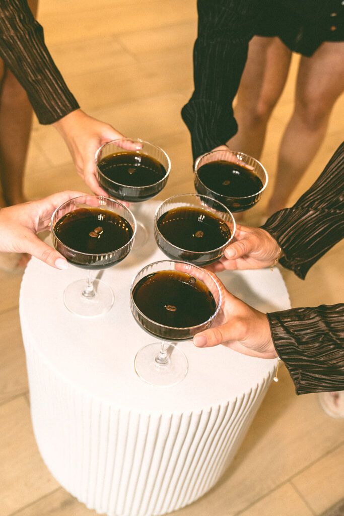 Bride and bridesmaids pick up espresso martini in classic coup glasses