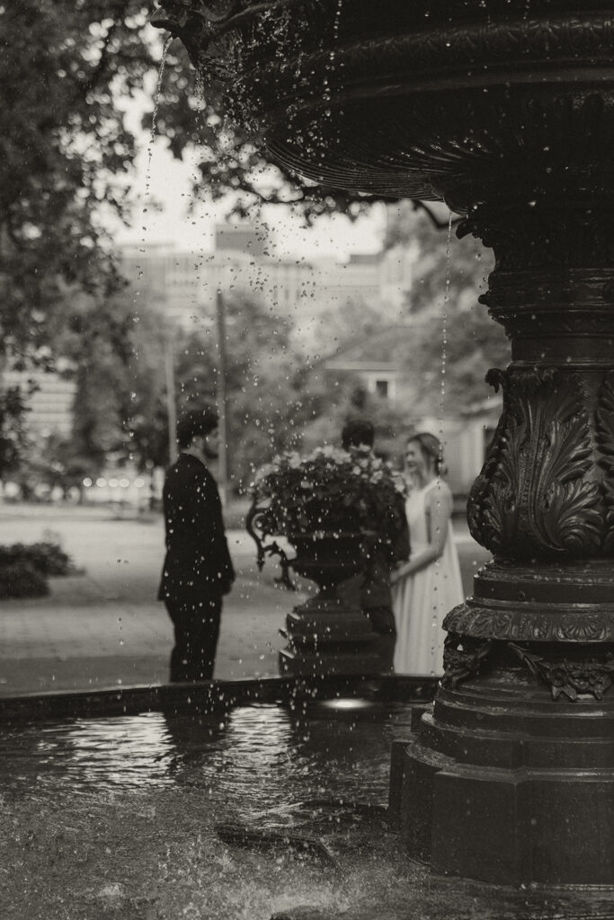 Black and white photo of couple framed by the fountain during their Minnesota elopement.