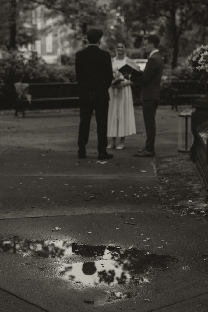 Black and white elopement photo of the couple exchanging vows by the fountain at Irvine Park.