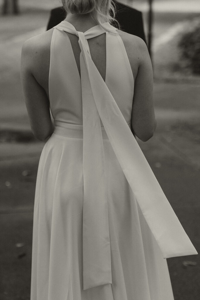Back of Polina’s dress trailing as she stands in Irvine Park for her wedding ceremony.