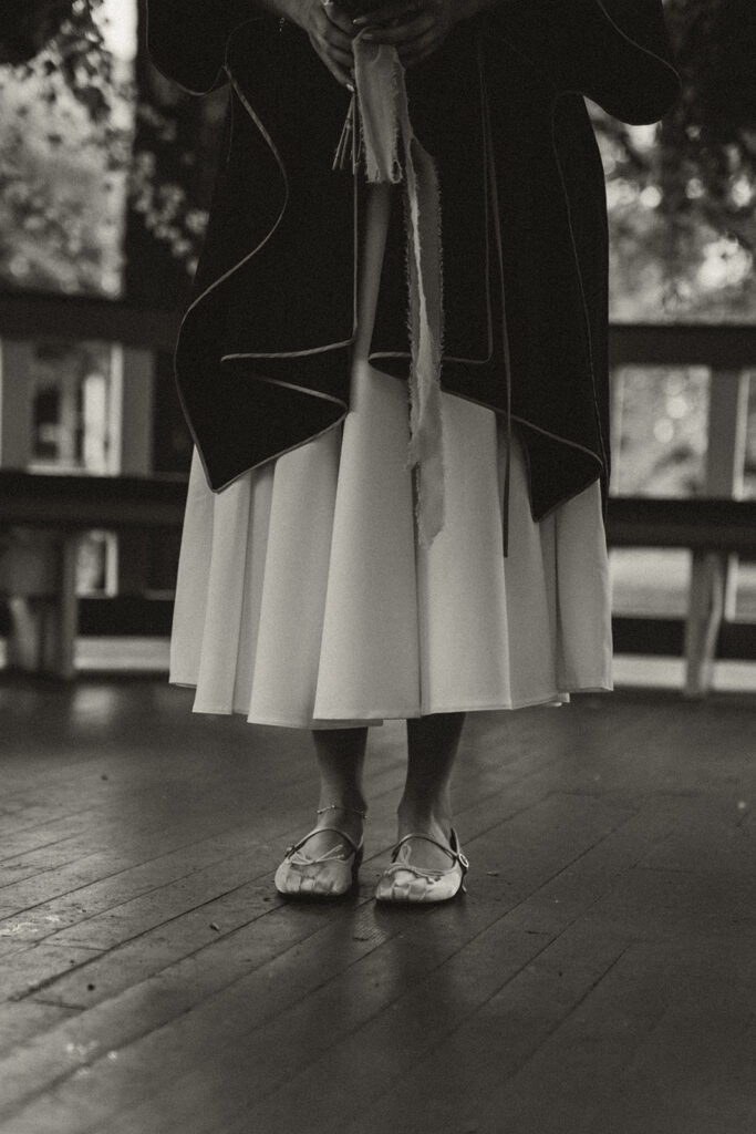 Bride stands in her dress and slippers waiting in the gazebo before the ceremony.