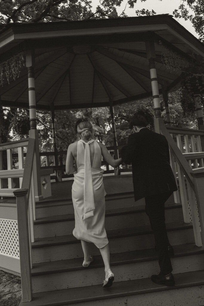 Bride and groom step into the gazebo together after their Minnesota elopement ceremony.