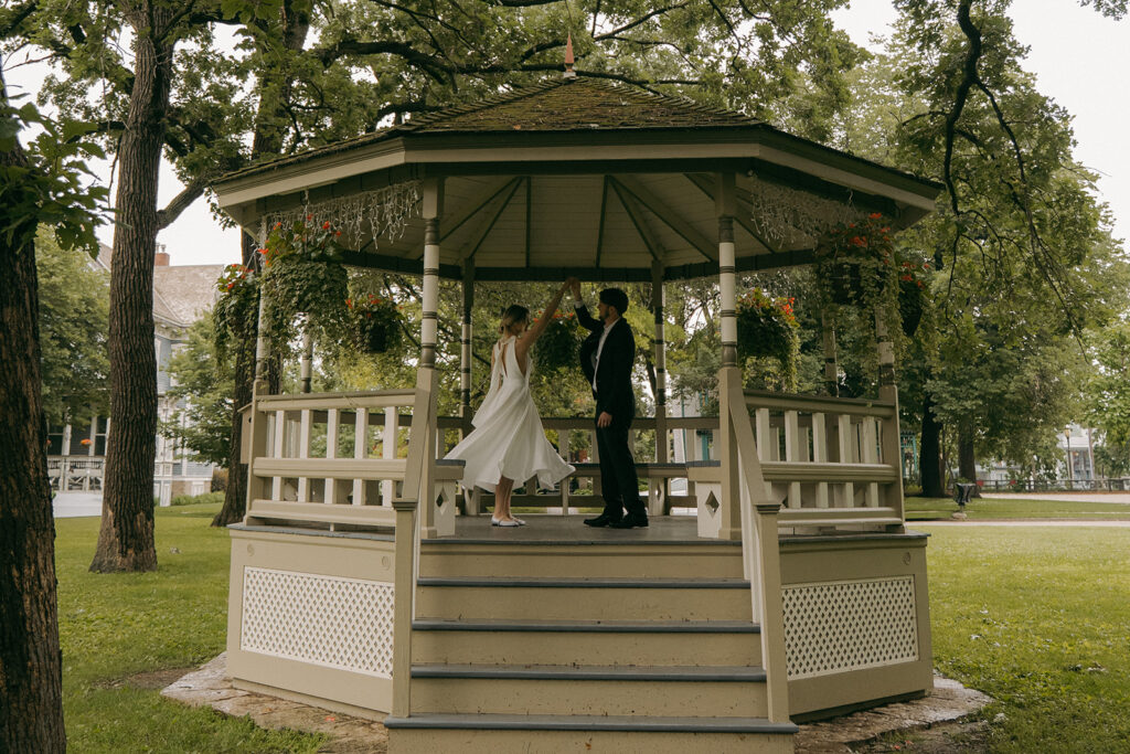 Bride and groom twirl in the gazebo for their Irvine Park wedding.