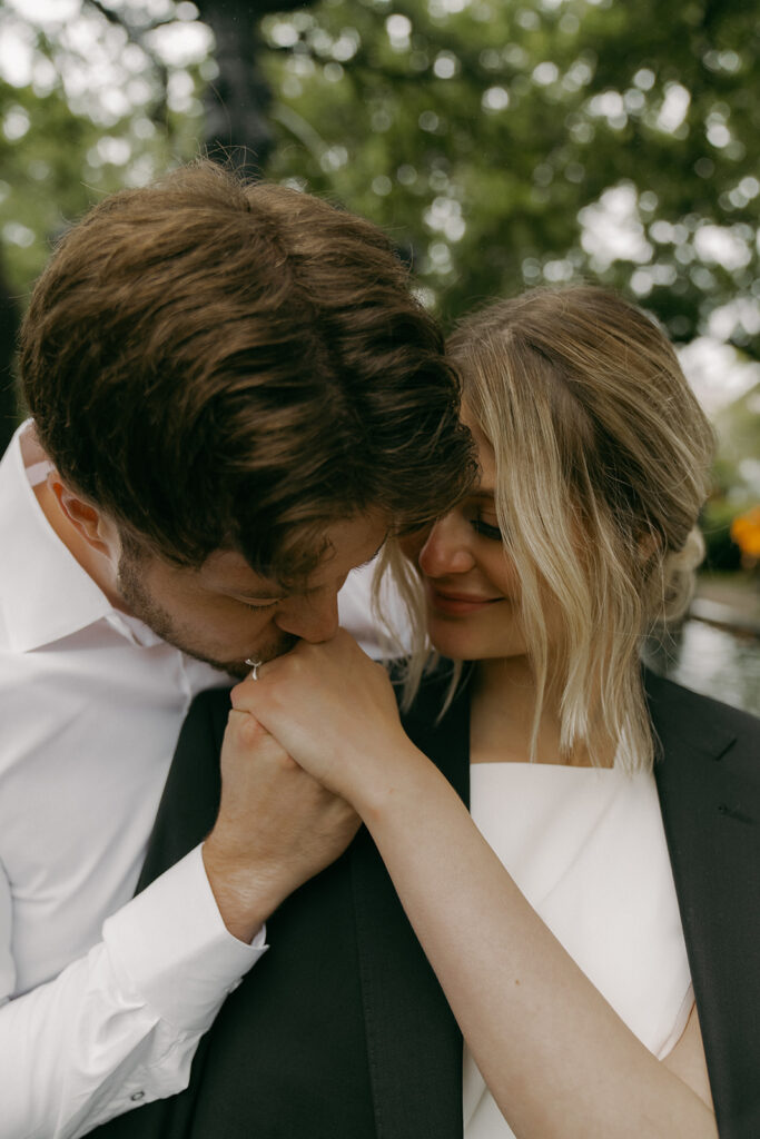 Groom holds bride close while she leans into him, captured in emotional elopement photos.