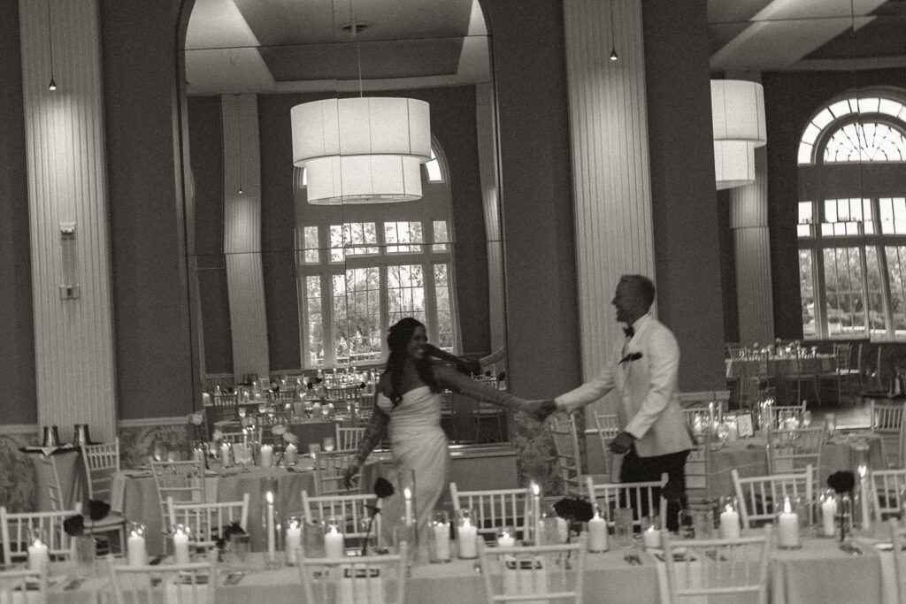 Bride and groom dancing through candlelit tables in an elegant St. Paul ballroom.