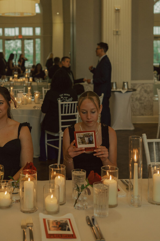 Guests admiring custom table details and family photos during a classy Twin Cities wedding reception.