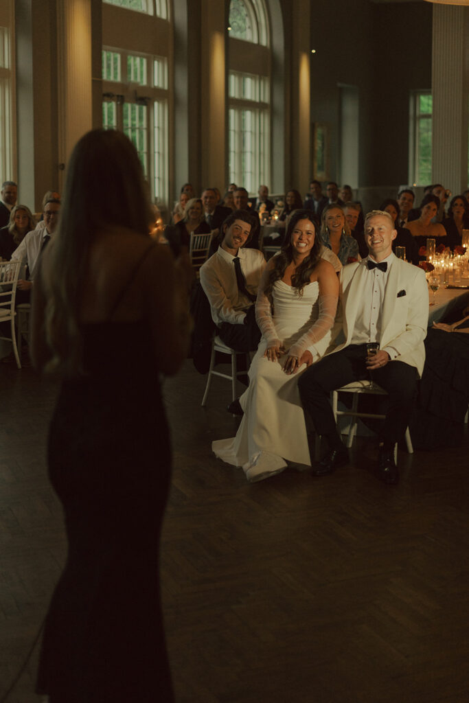 Guests giving heartfelt speeches under warm candlelight during a black-tie St. Paul wedding dinner.