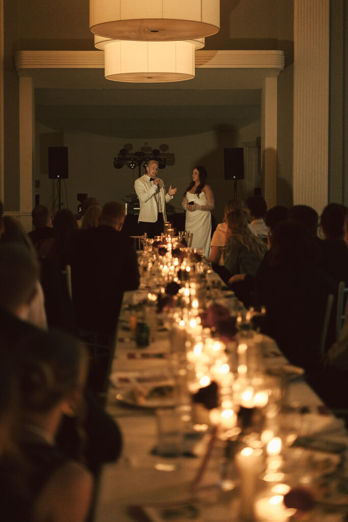 Bride and groom giving heartfelt speeches under soft candlelight in St. Paul, Minnesota.