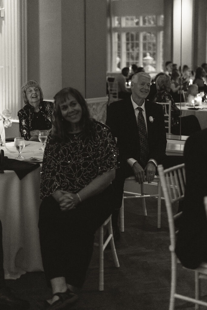 Guests smiling listening to speeches at a timeless wedding in St. Paul, Minnesota.