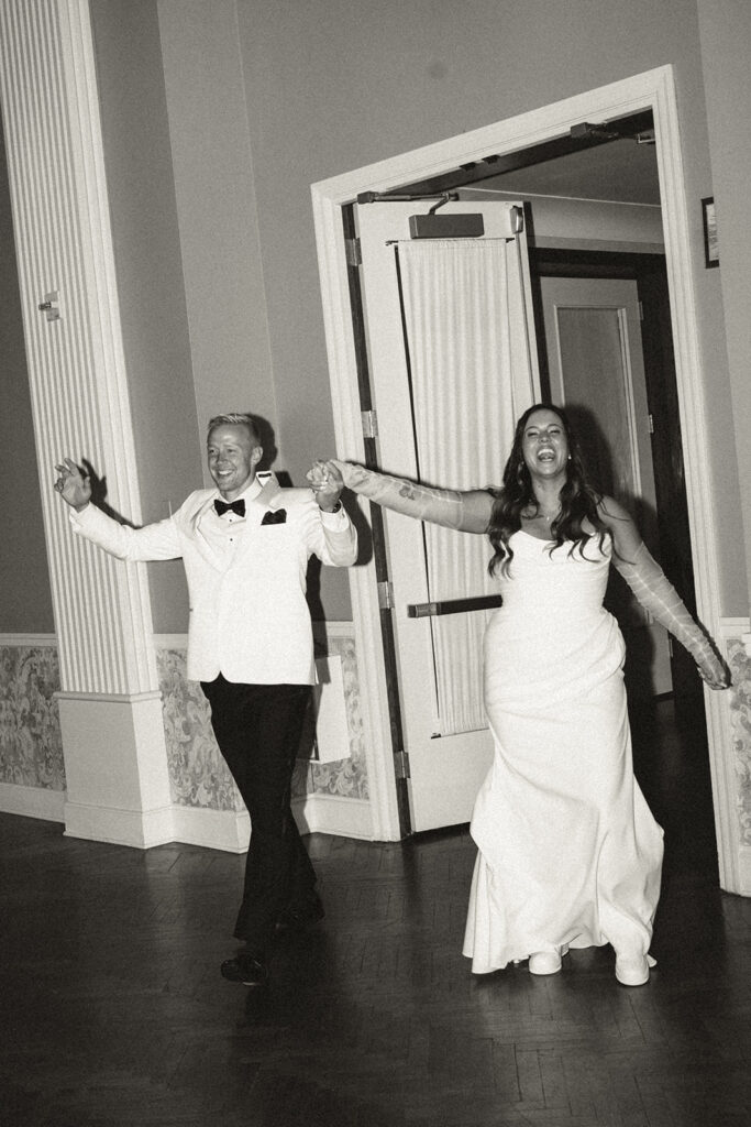 Bride and groom entering their elegant Twin Cities ballroom, captured with timeless wedding photography.
