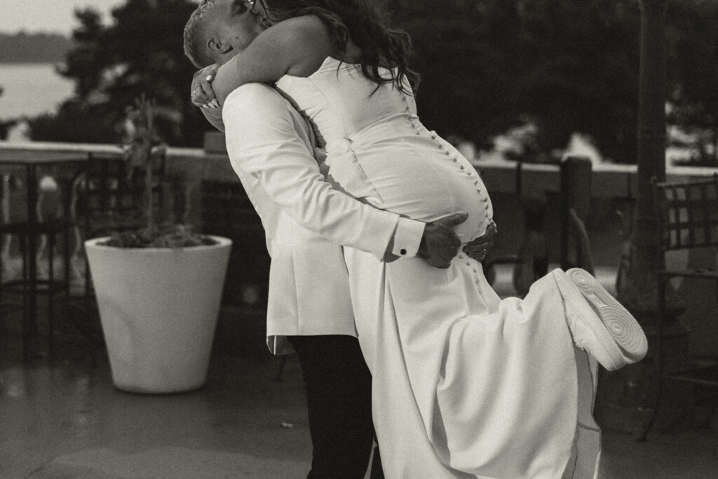 Groom lifting the bride into an embrace outside their St. Paul wedding venue, captured with timeless wedding photography.