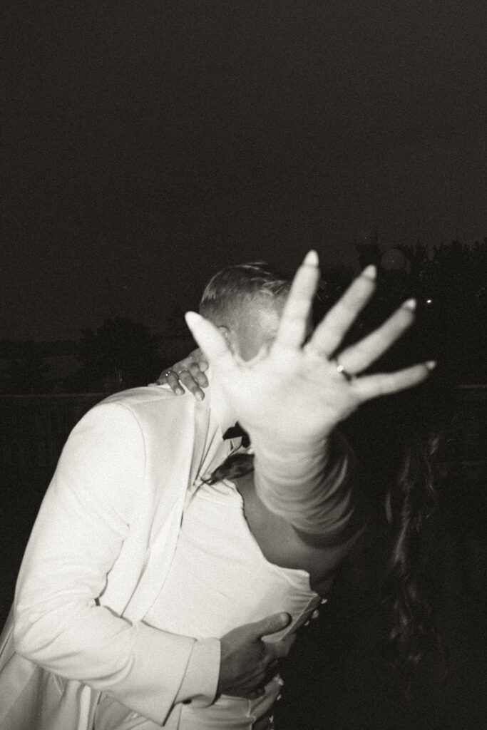 Bride and groom kissing in the rain after their timeless Twin Cities wedding reception.