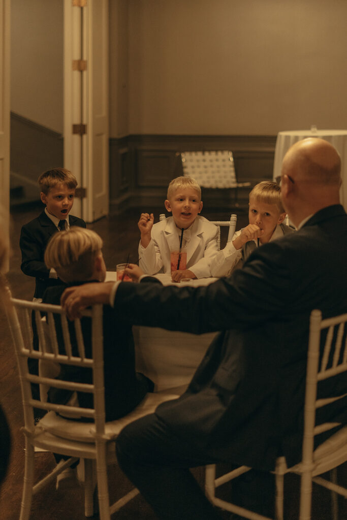 Family and friends sharing laughter during a cozy, candlelit Twin Cities wedding dinner.