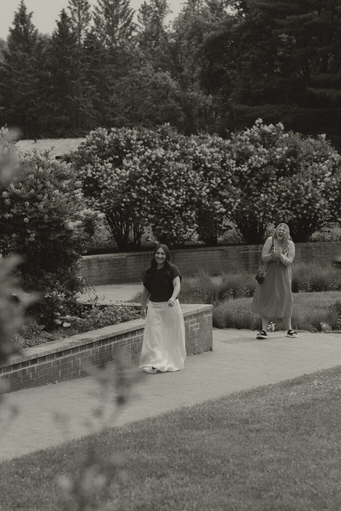 Bella spotting Joey across the garden, beginning to realize what’s happening as friends look on.