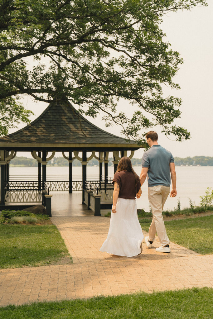 The couple walking toward the lakeside gazebo at Noerenberg Gardens, hand in hand.