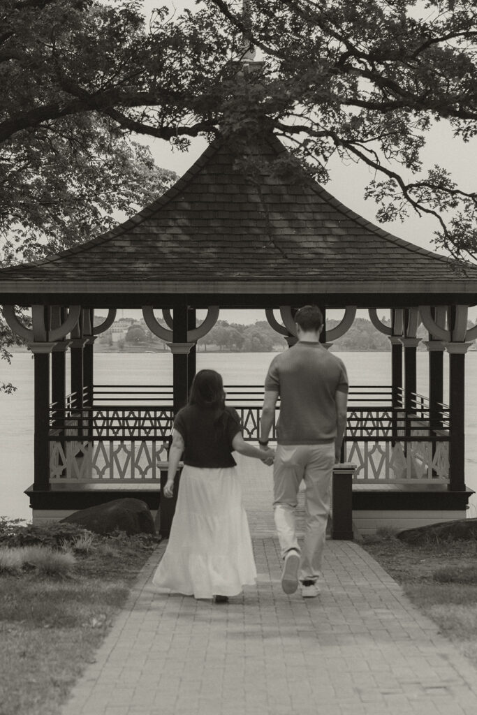 Joey and Bella stepping into the gazebo overlooking the lake, captured from behind.