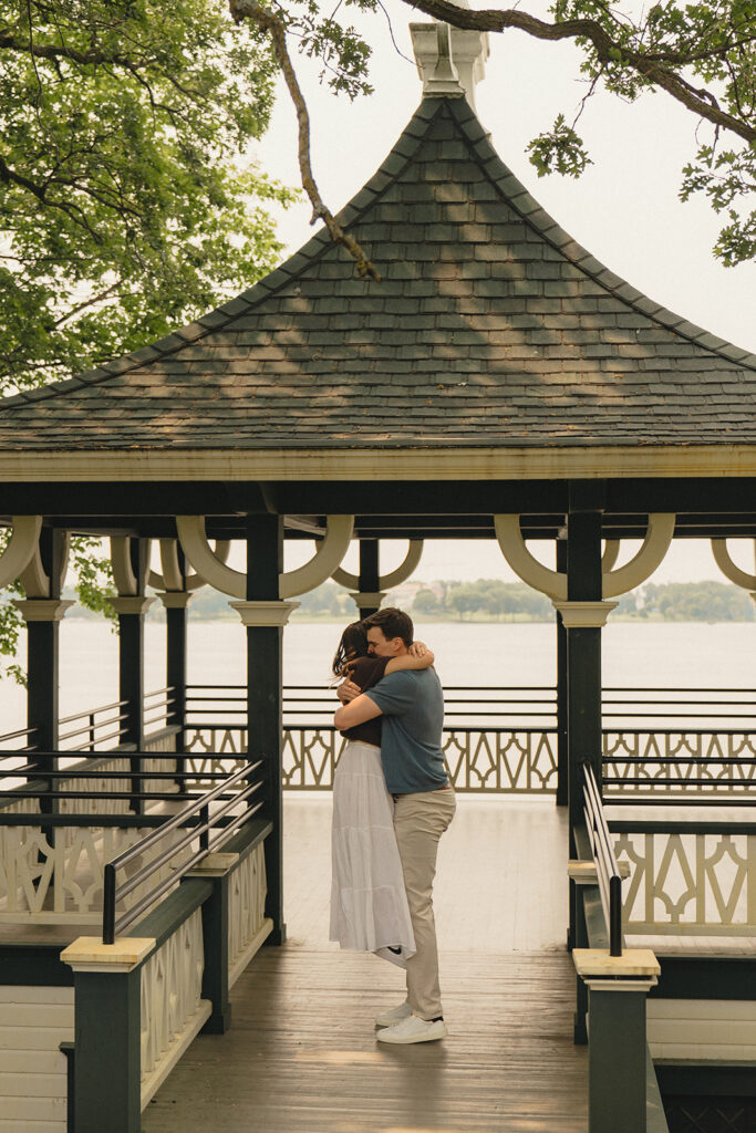 Joey lifting Bella into a hug inside the lakeside gazebo at Noerenberg Gardens in Wayzata, MN.