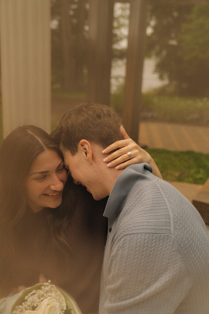 Bella leaning into Joey’s shoulder as he kisses her forehead, both smiling softly.
