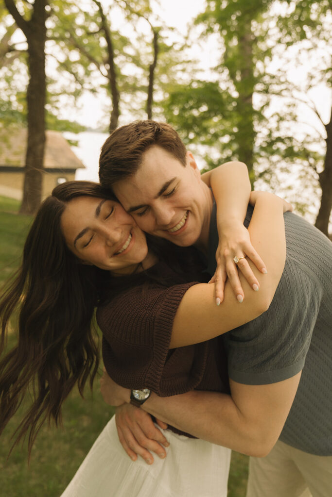 Joey and Bella wrapped in an embrace, laughing as he lifts her slightly off the ground, captured by wedding proposal photographer.