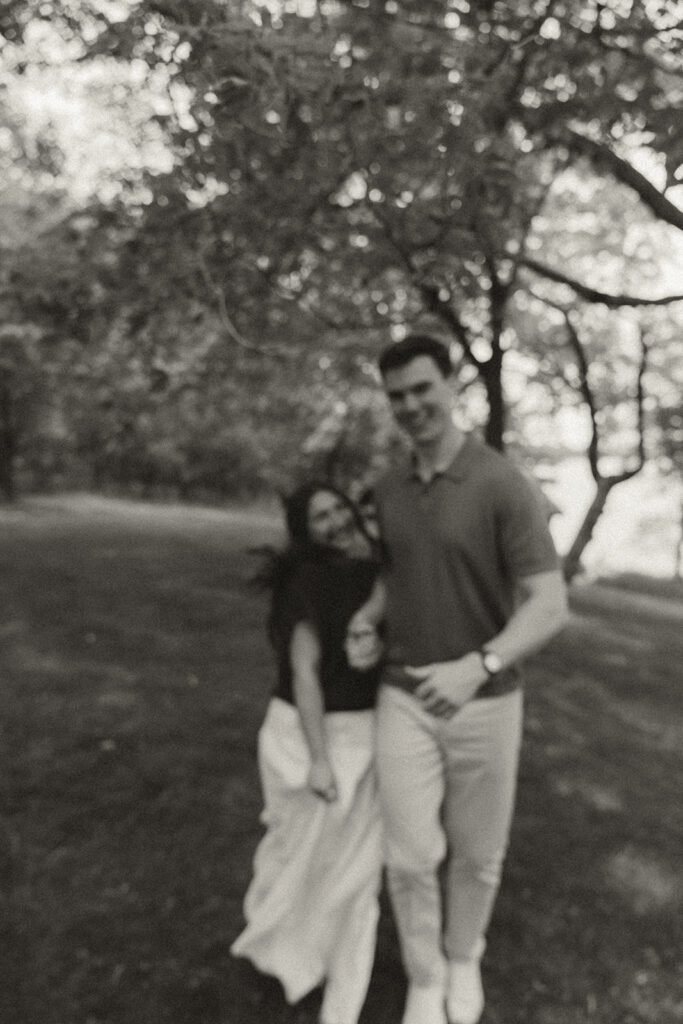 Joey and Bella walking arm-in-arm through the trees at Noerenberg Gardens, still giddy from the proposal.