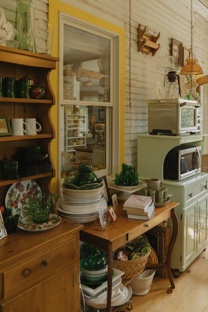 Antique dishes, green glassware, and heirloom decor styled inside Grandma’s farmhouse, showing the meaningful details that elevate a backyard wedding venue.