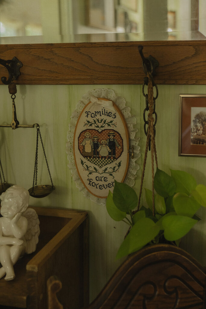 A Families Are Forever wall hanging and vintage decor inside the farmhouse, highlighting the emotional roots of this backyard wedding day.