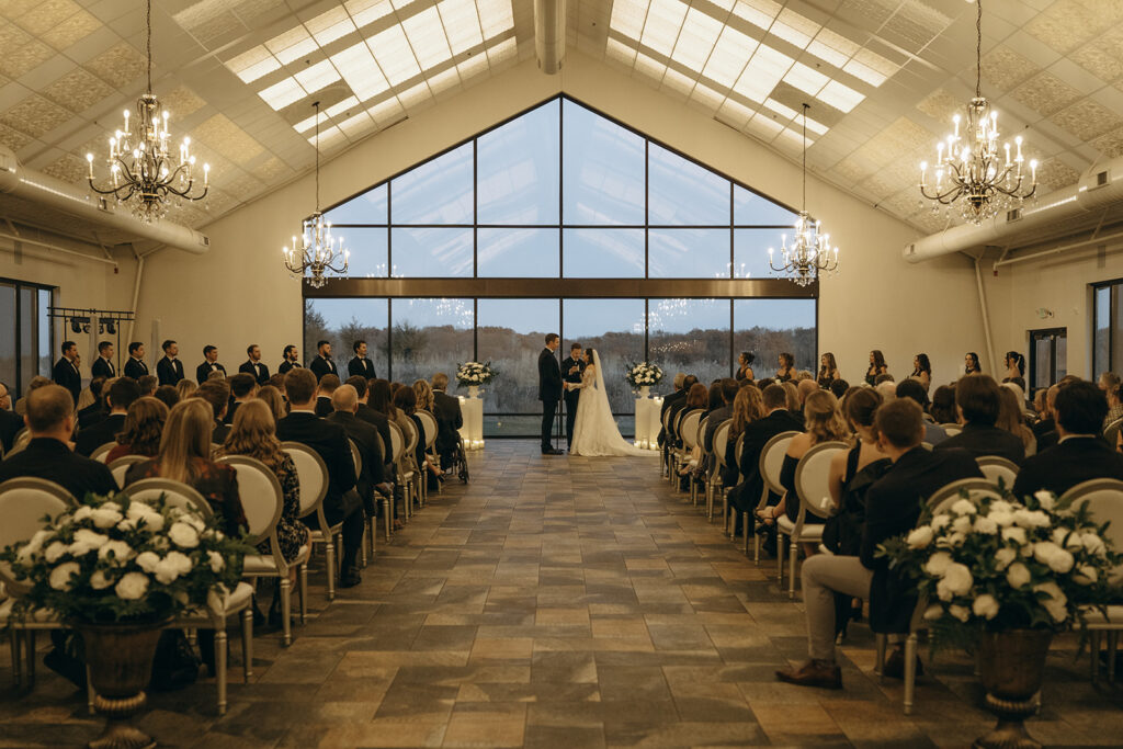 Bride and groom exchange vows as wedding guests look on during ceremony at Edward Anne Estate