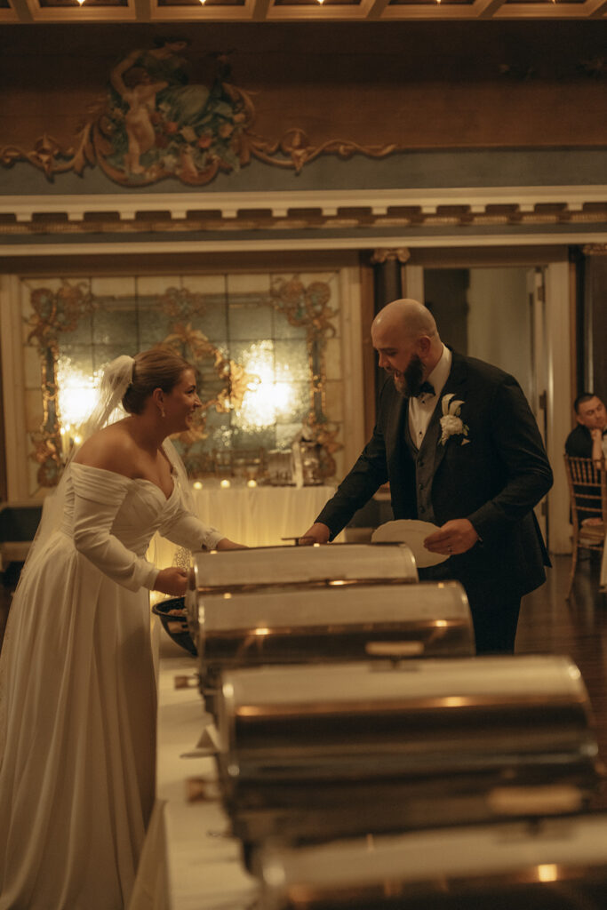 Bride and groom make their plates at vintage wedding reception
