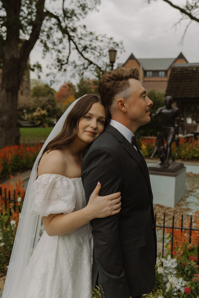 Vintage wedding aesthetic couples portrait where bride rests her head against her groom's back