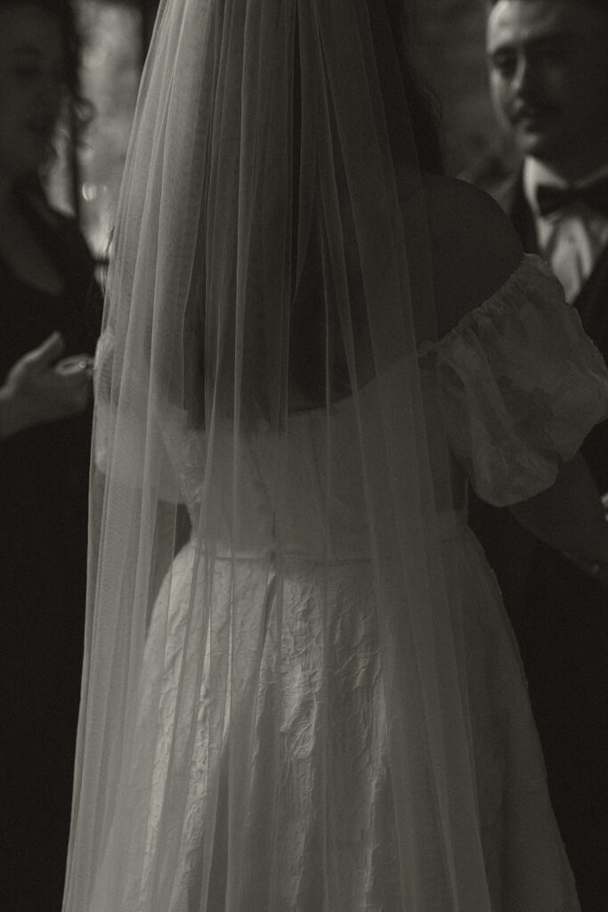 Bride's veil cascades down her back during vintage wedding ceremony