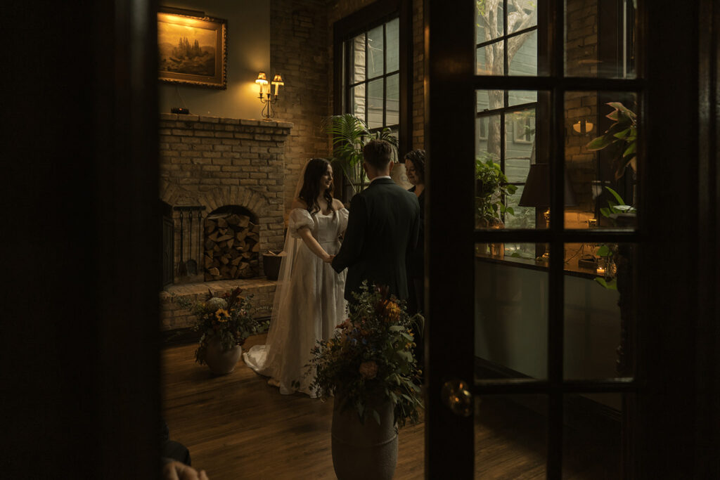 Bride and groom stand hand in hand at the altar during their wedding vows