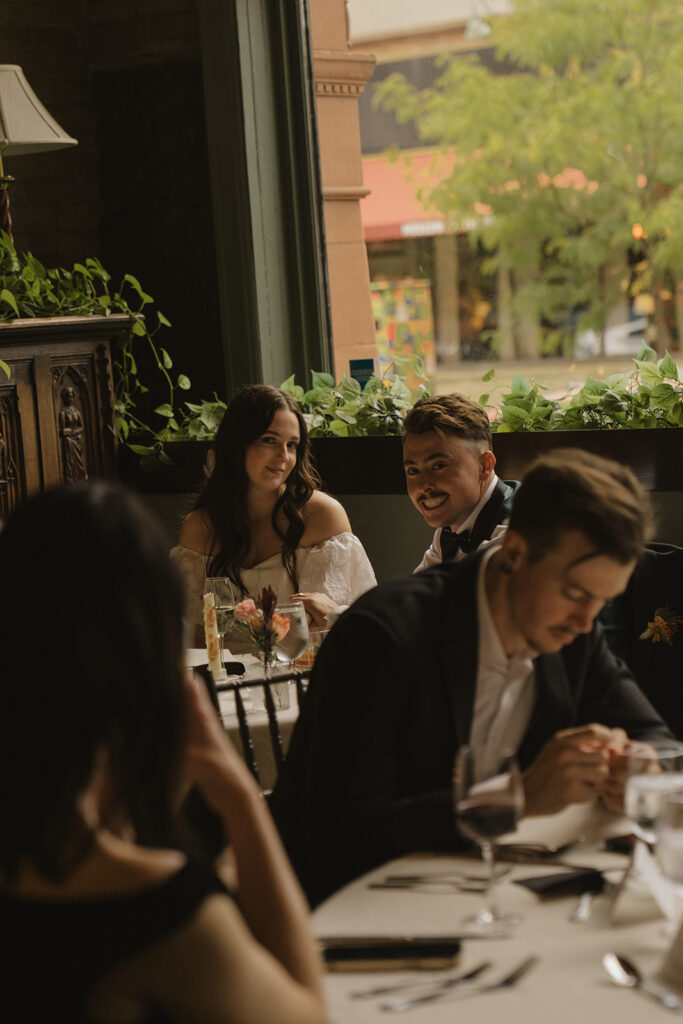 Bride and groom smile at the camera during candid moment in vintage wedding pics