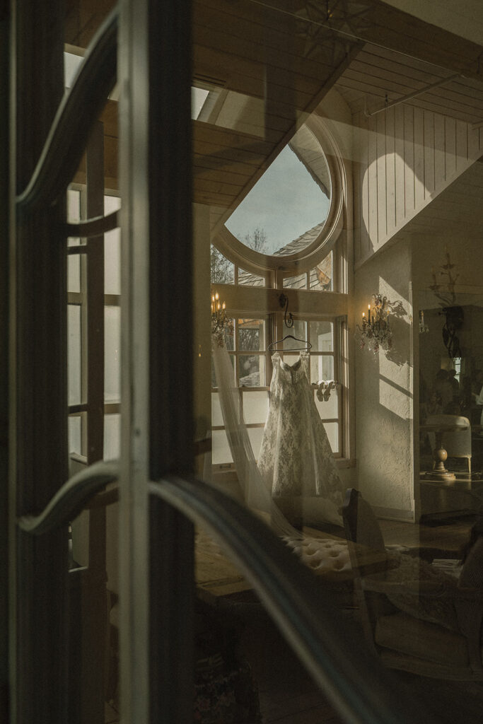Vintage wedding dress hangs in the morning light at Edward Anne Estate in Minnesota