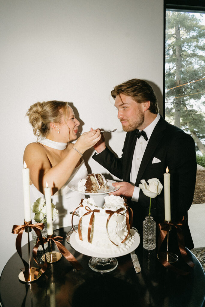 Bride and groom feed each other a bite of cake from each other's fork at the same time for vintage wedding cake ideas