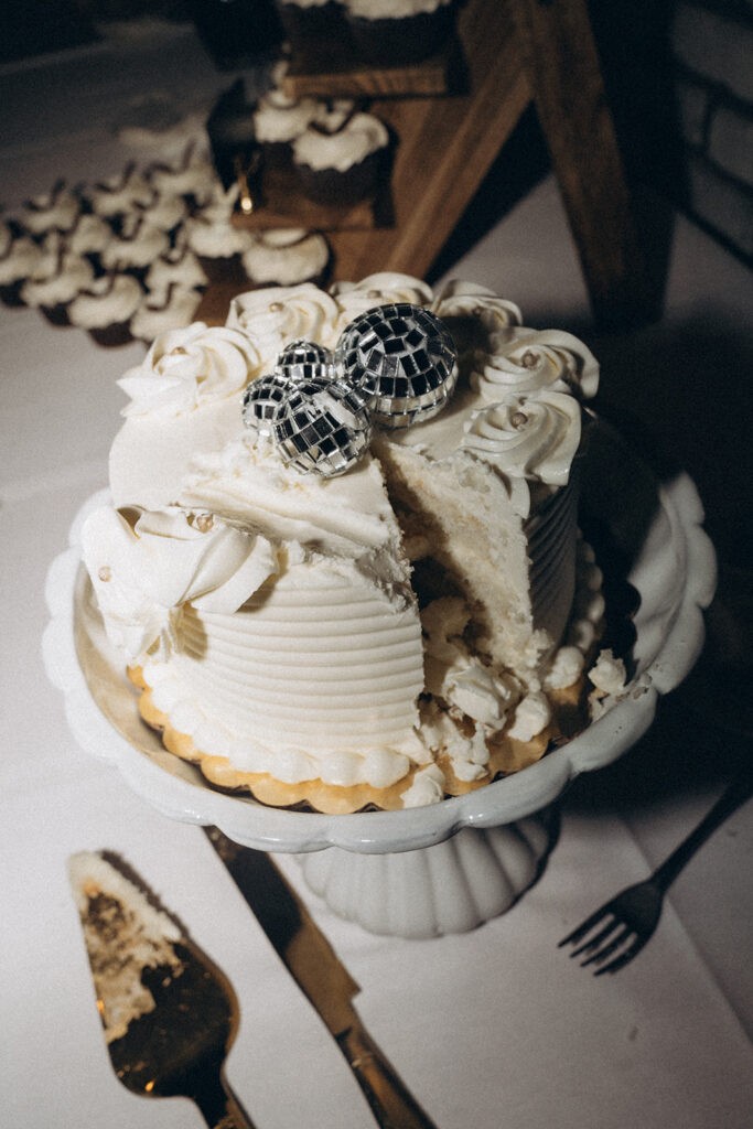 Fun and personality-packed vintage wedding cake ideas with thick white frosting on a round wedding cake topped with disco balls