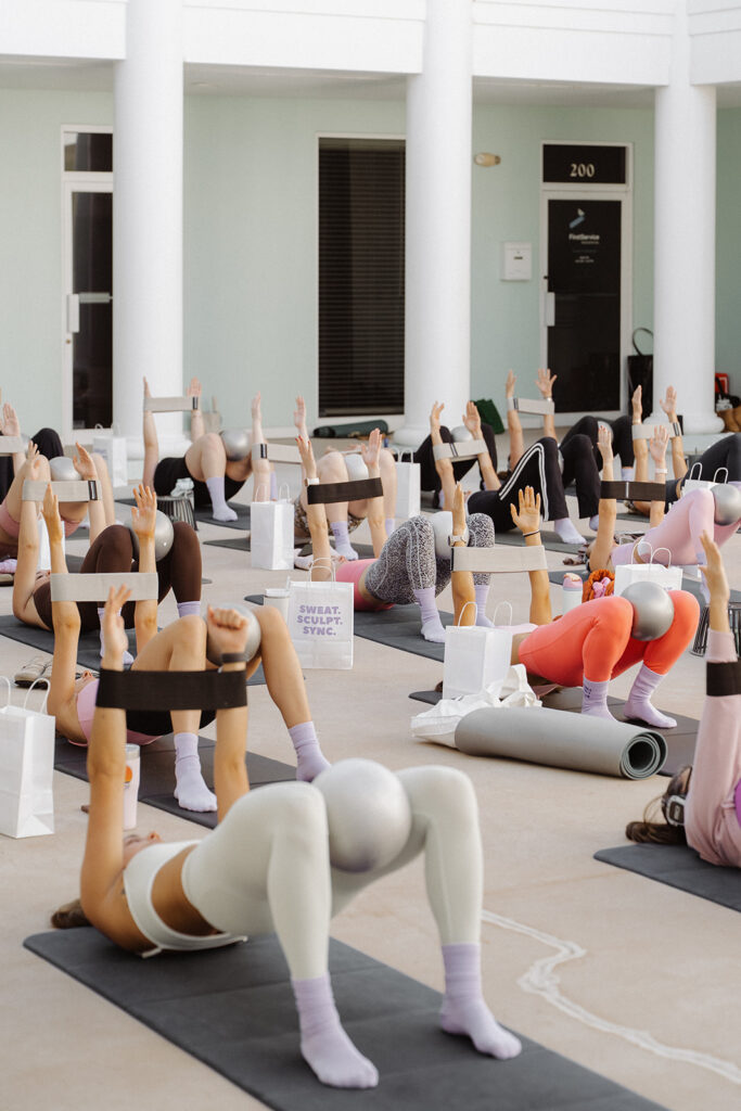 Women exercising on mats with pilates balls and branded bags, community branding photos for Garnuu.