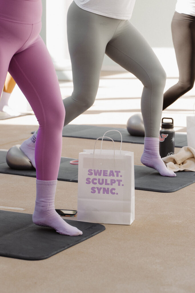 Close-up of pastel leggings and Garnuu gift bag during sculpt event, modern brand photoshoot styling.